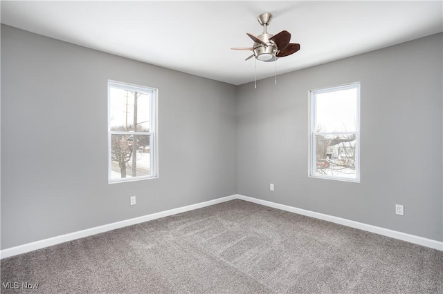 carpeted empty room featuring a healthy amount of sunlight, baseboards, and a ceiling fan