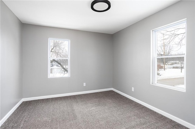 carpeted spare room with baseboards