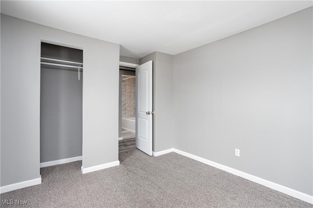 unfurnished bedroom featuring a closet, baseboards, and carpet flooring