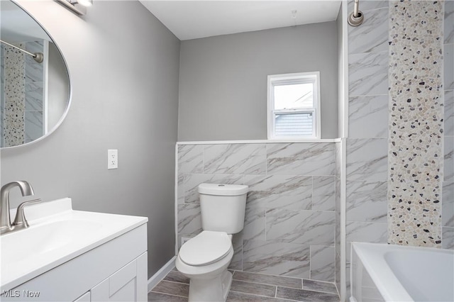 full bath featuring toilet, washtub / shower combination, tile walls, and vanity