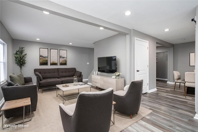 living room featuring baseboards, wood finished floors, and recessed lighting