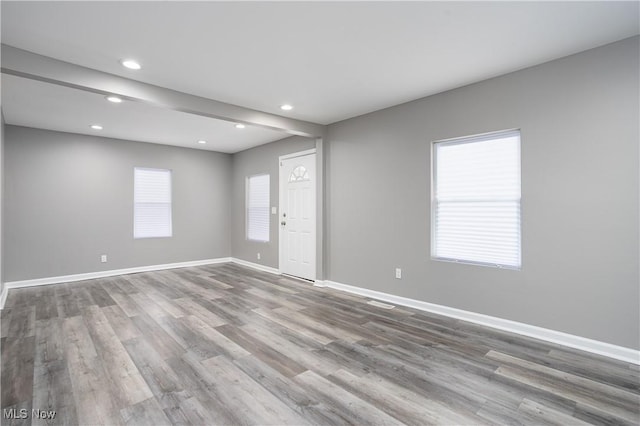 unfurnished room with light wood finished floors, baseboards, and recessed lighting