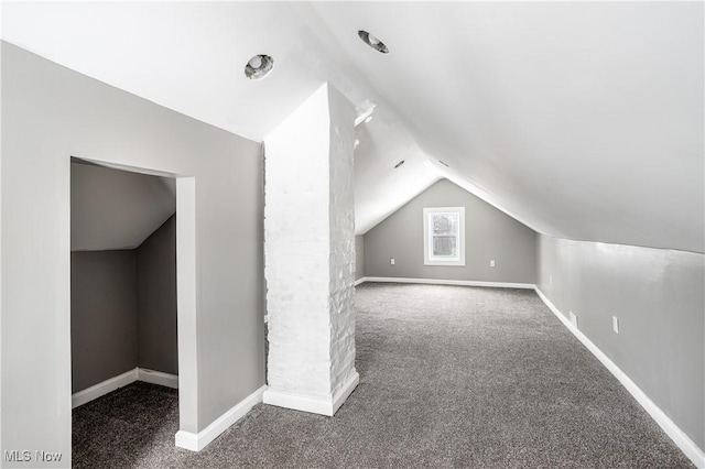 additional living space with baseboards, vaulted ceiling, and carpet flooring