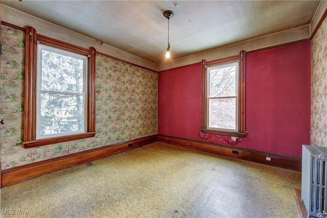 unfurnished room with baseboards, carpet flooring, radiator heating unit, and wallpapered walls