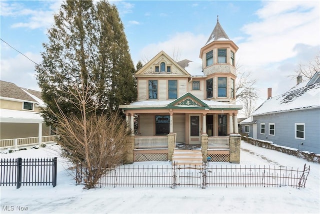 victorian house featuring covered porch and fence