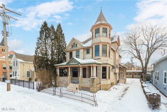 victorian-style house featuring covered porch, a residential view, and fence