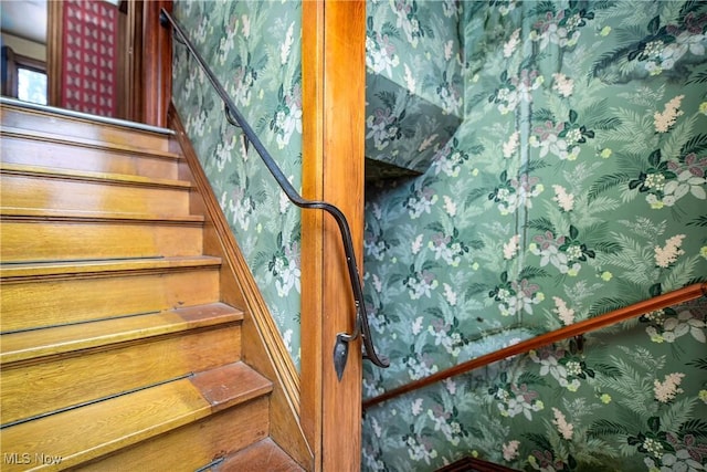 staircase with wallpapered walls