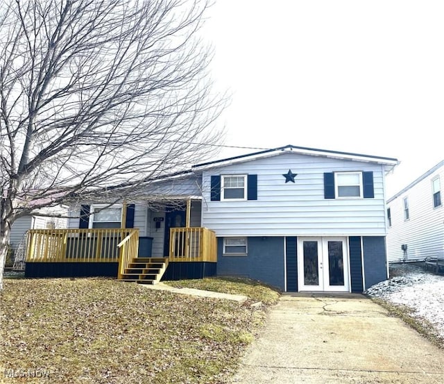 split level home with driveway, a deck, and french doors