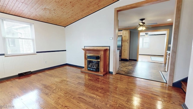 unfurnished living room with a glass covered fireplace, wooden ceiling, vaulted ceiling, and wood finished floors