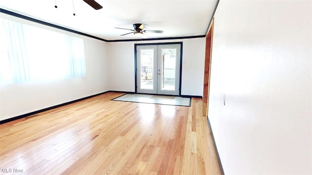 spare room featuring ornamental molding, french doors, light wood-style flooring, and baseboards