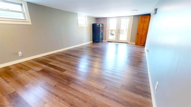 empty room with french doors, baseboards, and wood finished floors