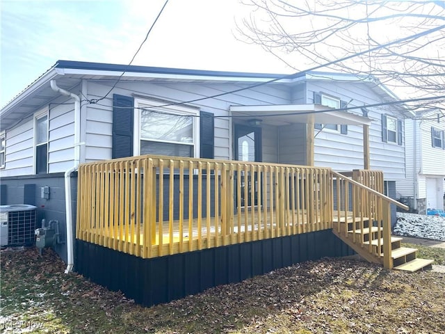 rear view of property with a wooden deck and central air condition unit