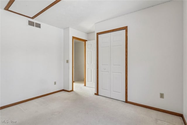 unfurnished bedroom featuring light carpet, baseboards, visible vents, and a closet