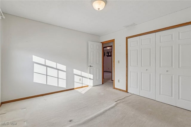 unfurnished bedroom with baseboards, a closet, visible vents, and light colored carpet