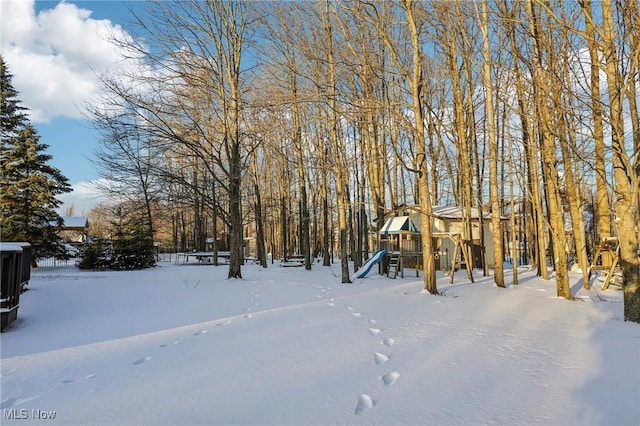 yard layered in snow featuring a playground