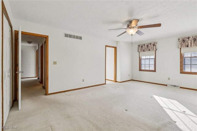 unfurnished room featuring ceiling fan, light carpet, visible vents, and baseboards