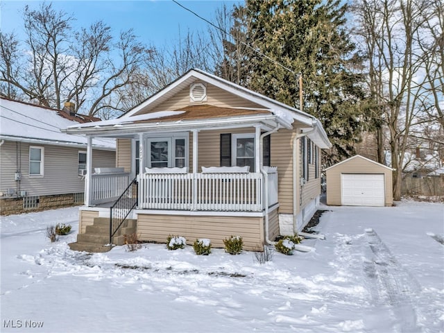 view of front of property featuring a detached garage, a porch, and an outdoor structure