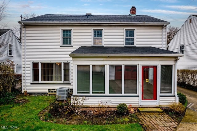 19951 Fairmount Blvd, Shaker Heights, OH 44118 - rear view of house featuring a sunroom, central AC, a chimney, a lawn, and roof with shingles