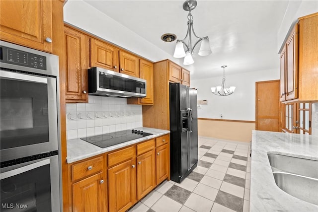 19951 Fairmount Blvd, Shaker Heights, OH 44118 - kitchen with a chandelier, black appliances, tasteful backsplash, and brown cabinets