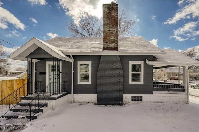 exterior space with roof with shingles, fence, and a chimney