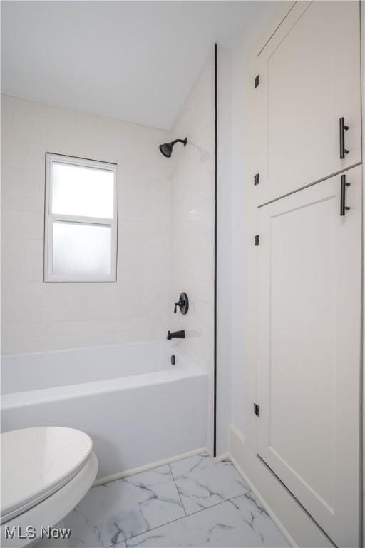 full bathroom featuring toilet, marble finish floor, and shower / bathtub combination