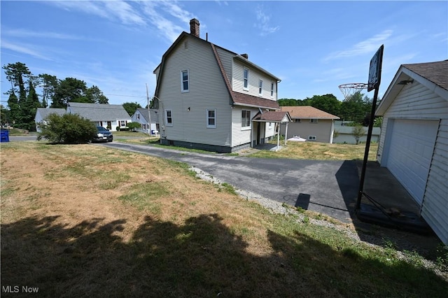 view of property exterior featuring a lawn, a chimney, and a gambrel roof