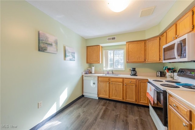 kitchen with light countertops, white appliances, a sink, and visible vents