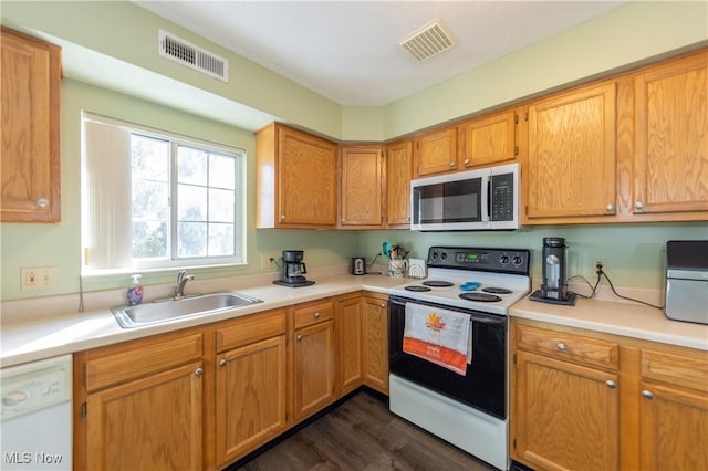 kitchen featuring light countertops, white appliances, a sink, and visible vents