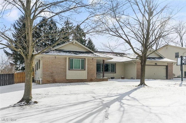 single story home with brick siding, an attached garage, and fence