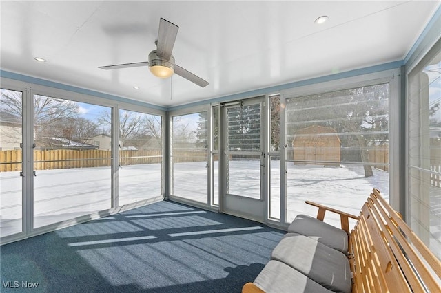 unfurnished sunroom with a ceiling fan