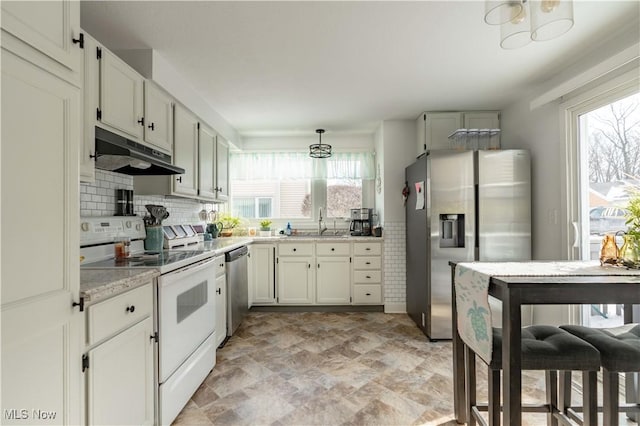 kitchen featuring white cabinets, hanging light fixtures, stainless steel appliances, under cabinet range hood, and backsplash