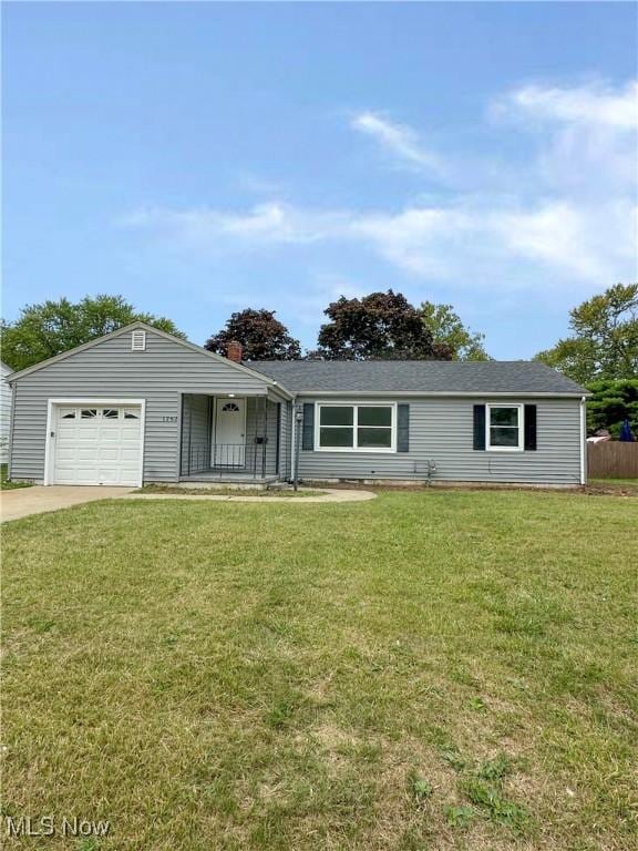 single story home with a garage, driveway, and a front lawn