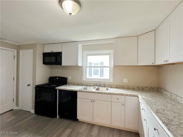 kitchen with white cabinets, a sink, and black appliances