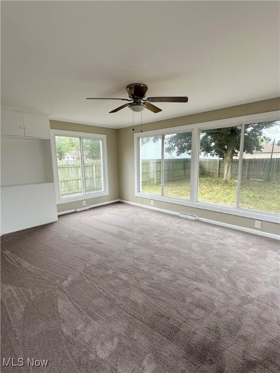 carpeted spare room featuring visible vents, baseboards, and a ceiling fan