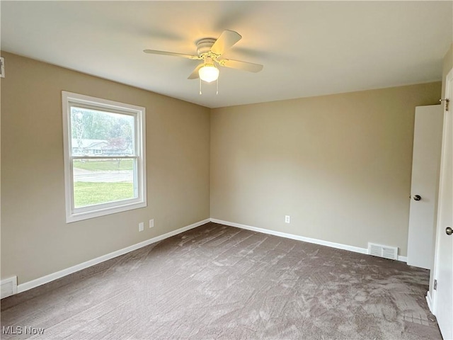 unfurnished room featuring carpet floors, ceiling fan, visible vents, and baseboards