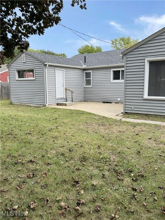 rear view of house with a patio and a yard