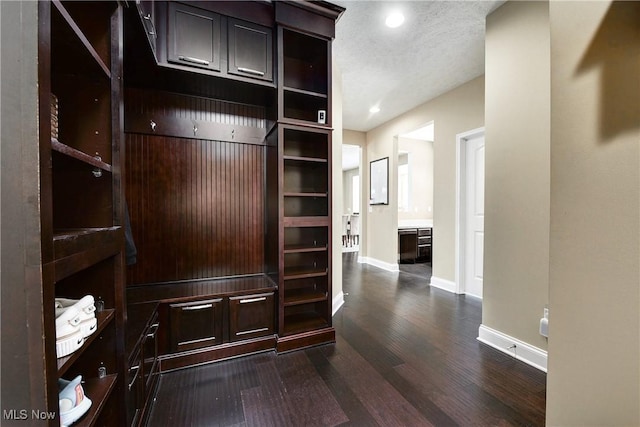 mudroom featuring a textured ceiling, dark wood-type flooring, recessed lighting, and baseboards