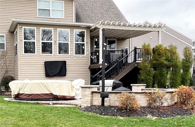 rear view of property featuring a shingled roof, a lawn, stairway, a deck, and a pergola