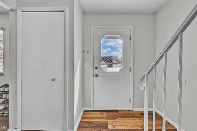 foyer featuring stairs, light wood-style flooring, and baseboards