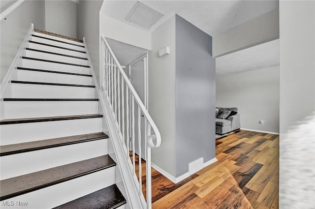 stairs with baseboards and wood finished floors