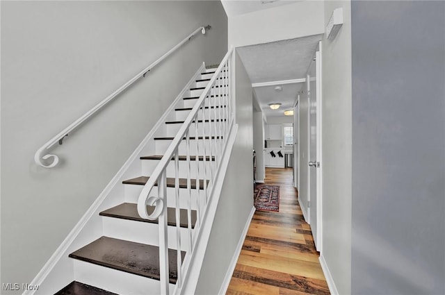 stairway featuring baseboards and wood finished floors