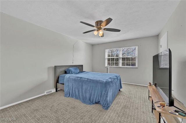 carpeted bedroom featuring a textured ceiling, visible vents, a ceiling fan, and baseboards