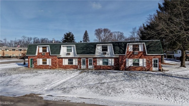 view of front of house with mansard roof and brick siding