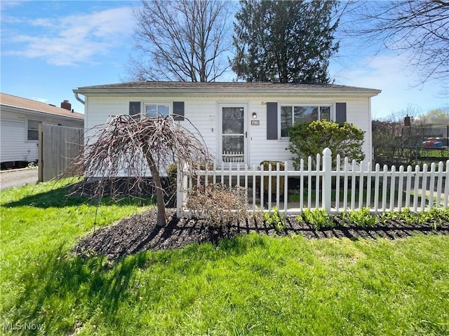 view of front of home featuring a front lawn and fence