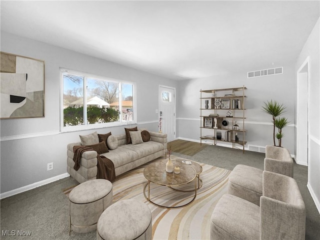 living area featuring baseboards and visible vents