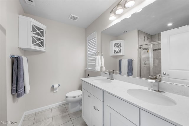 bathroom featuring tile patterned flooring, visible vents, a sink, and a shower stall