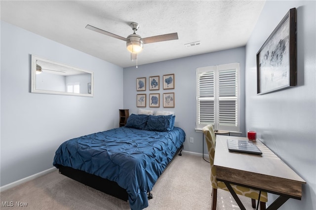 bedroom featuring visible vents, light colored carpet, ceiling fan, a textured ceiling, and baseboards