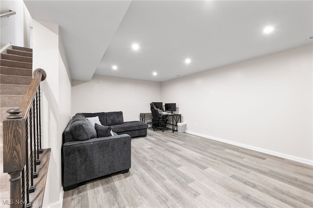 living area with recessed lighting, light wood-style flooring, baseboards, and stairs