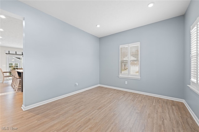 spare room with light wood-type flooring, baseboards, and recessed lighting