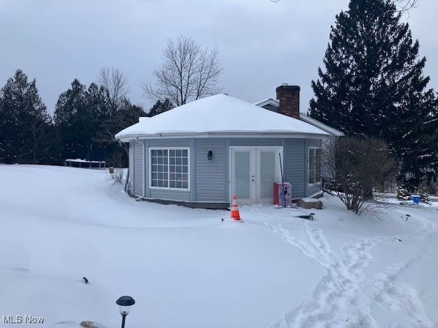 snow covered property featuring a chimney